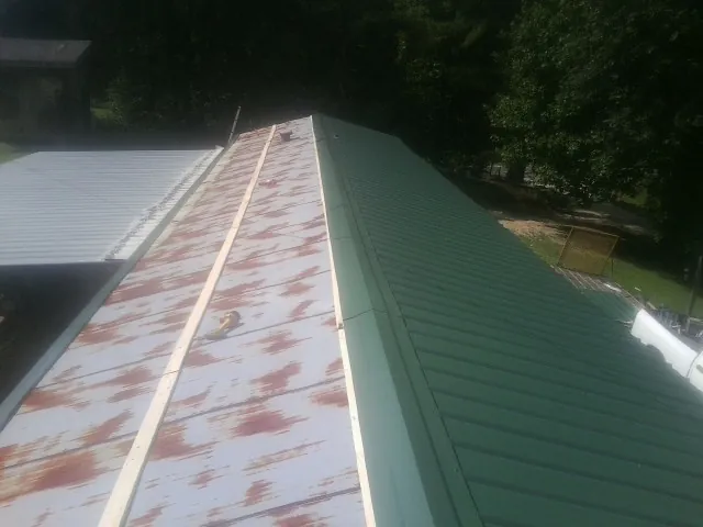 Old rusted panels beside newly installed green metal roofing — Wind Damage Roof Repair by Roofing Brothers in West Lafayette